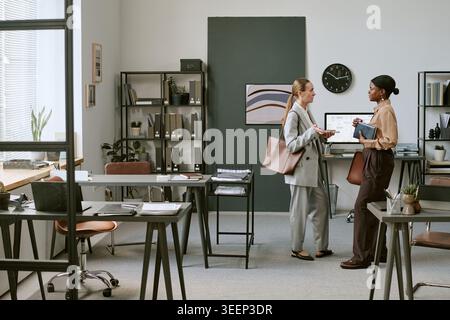 Businesswomen Discussing Project Strategy in Modern Office Stock Photo