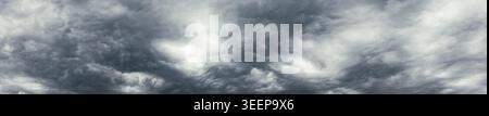 panoramic dark cloudy sky background. Heavy dark gray clouds in the overcast sky. Stock Photo