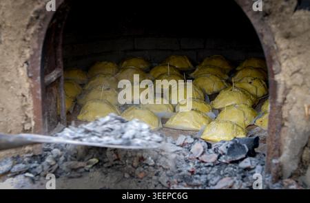 Traditional Cypriot easter pastries made with mixture of various cheese and halloumi, baked in clay oven using a wooden peel flaounes flaouna Stock Photo