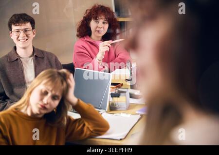 Creative office workers listening during team presentation in modern workspace. Stock Photo