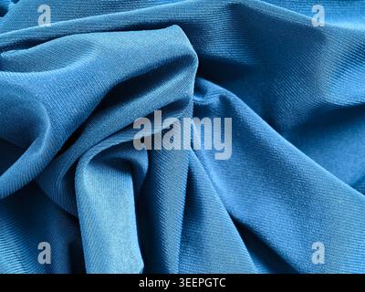 Blue knitted jersey fabric texture showing soft folds and ripples, creating a calming abstract background Stock Photo