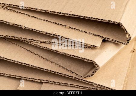old cardboard from boxes folded for storage, used old cardboard from recycled paper is stored after using it as packaging material, close up Stock Photo