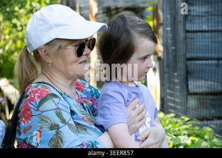 Happy grandmother and grandchild spending time together in the zoo Stock Photo