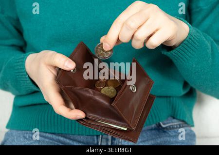 Hands put the change in the wallet. The Concept of Money Stock Photo