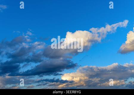 Gentle cloud formations against a blue sky at dusk Stock Photo