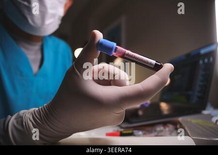 Scientist analyzing antavirus positive blood sample in a research laboratory setting Stock Photo