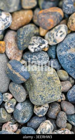 Close up on various river stones different sizes and shapes. Soft natural light enhances textures and colors. Concept for wellness, relaxation and spa Stock Photo
