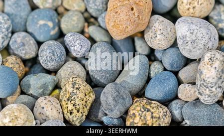 Close up on diverse rock pile. Soft diffused light accentuates textures in mottled grays, blues, tans. Useful for backgrounds in mindful wellness conc Stock Photo