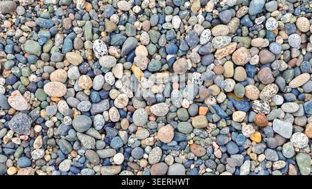 Pebbles of many colors textures fill entire frame, minimalist design. Blues, greys, tans hues evoke calm feeling. Great for wallpaper, background or b Stock Photo