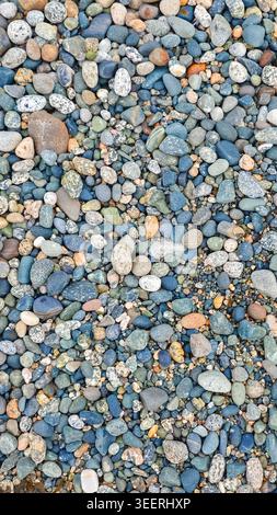 Close up on smooth pebbles. Background features textures and patterns. Blue, grey, and brown color palette. Use for backgrounds related to wellness or Stock Photo