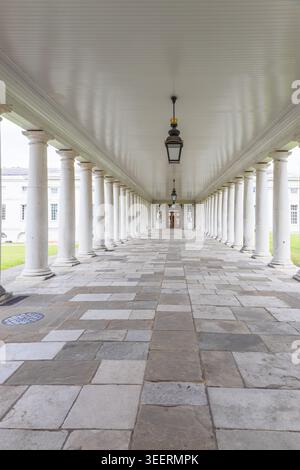 Long empty colonnade with white pillars and stone floor Stock Photo