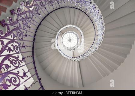Top down view of an elegant spiral staircase with ornate iron railings Stock Photo
