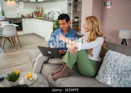 Couple relaxing on sofa using laptop at home Stock Photo