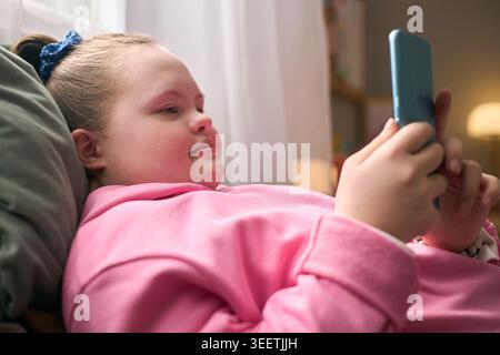 Girl with Down Syndrome Using Smartphone for Digital Communication Stock Photo