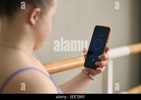 Girl with Down Syndrome Using Smartphone for Voice Assistant Stock Photo