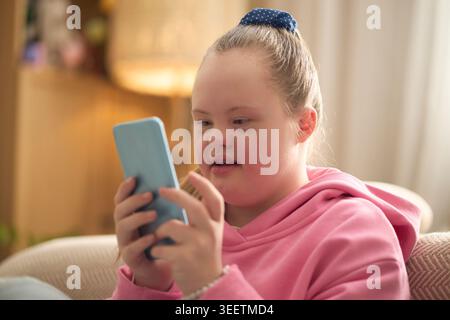 Girl with Down Syndrome Using Smartphone for Digital Communication Stock Photo