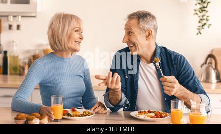 Couples Enjoy Breakfast Together in Bright Kitchen While Sharing Joyful Conversation Stock Photo