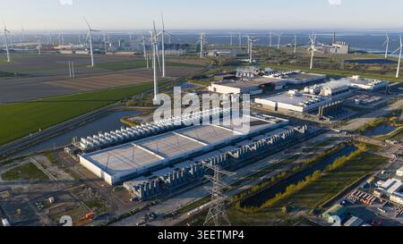 Aerial view of a large industrial data center facility and wind farm under a clear sky in Eemshaven, Groningen, Netherlands. Stock Photo