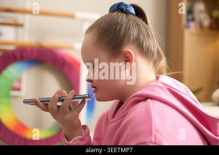 Girl with Down Syndrome Using Smartphone for Voice Communication Stock Photo