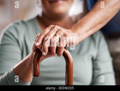 Home, support and old couple with walking stick, holding hands or empathy for partner with arthritis. Retirement, care and love for elderly person Stock Photo