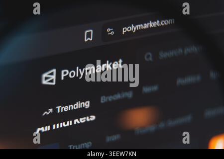 Polymarket website interface viewed through magnifying glass, decentralized prediction market platform for betting on politics, crypto, and global Stock Photo