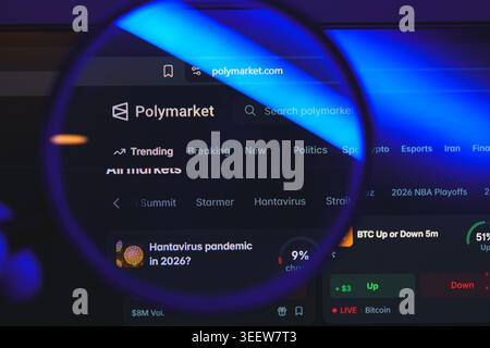 Polymarket website interface viewed through magnifying glass, decentralized prediction market platform for betting on politics, crypto, and global Stock Photo