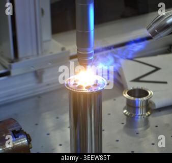 CNC Laser Cutting Machine. Automated laser precisely cutting metal. 5-axis robotic workbench for laser manufacturing. Accuracy automation. Sparks. Manufacturing processes. Precision CNC Technology Stock Photo