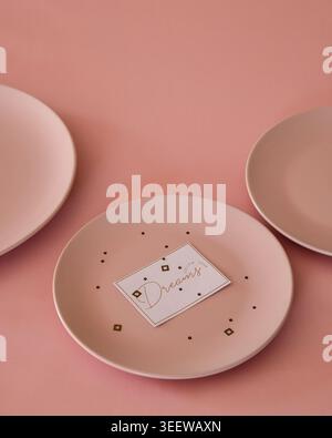 Minimalist pink setup showcasing ceramic plates on pastel background Stock Photo