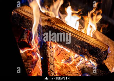 Glowing Log Fire With Dancing Flames And Embers, Closeup Of Burning Hardwood Logs, Blue And Orange Flame Tongues, Glowing Coals, Warm Rustic Stock Photo