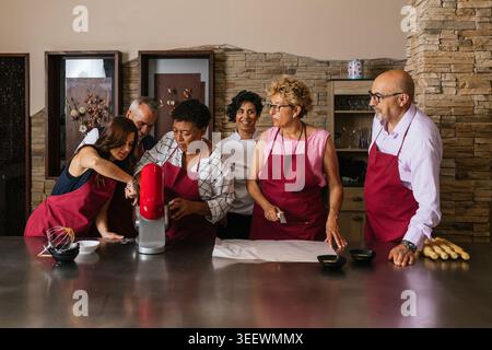 Chefs using professional equipment preparing food in restaurant kitchen Stock Photo