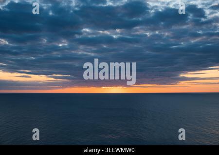 Dramatic sunrise over the deep blue sea horizon Stock Photo