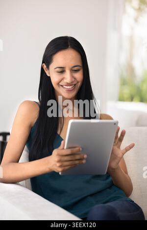 Pretty woman using digital tablet at home Stock Photo