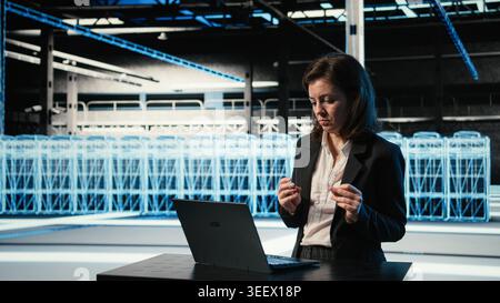 Happy server hub engineer dancing in celebration after fixing system errors with laptop. Ecstatic data center manager expressing excitement after reaching operational goals Stock Photo