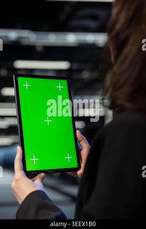 Green screen tablet, infrastructure rigs troubleshooting and admin in data center. Mockup device close up, checkup application and IT specialist solving system bug in server farm Stock Photo