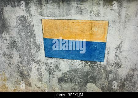 Flaking painted Ukraine Flag on a wall in Jalan Tinangol, Kudat, Sabah, Malaysia. Stock Photo