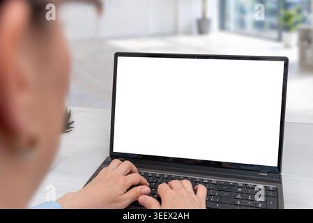 Close perspective of woman typing on laptop with isolated screen mockup, clean office environment designed for technology, business or education conce Stock Photo