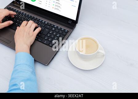Minimal workspace with laptop keyboard and coffee cup, featuring productivity dashboard interface in clean business environment with generous copy spa Stock Photo