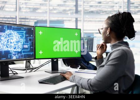 Green screen PC, optimizing hardware and female technician using AI in microchip factory RD office. Improving manufacturing efficiency, mockup computer and employee using artificial intelligence Stock Photo