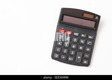 High-angle shot of a classic dual power sources solar and battery black handheld electronic calculator isolated on a clean white background. Stock Photo