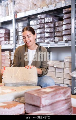 Young woman chooses pottery clay in shop Stock Photo