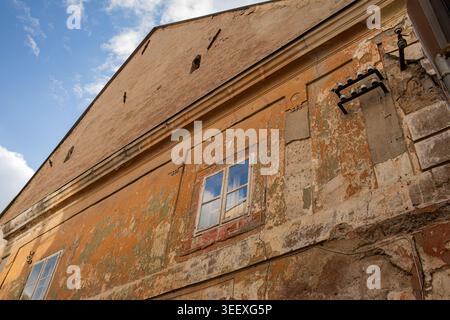 Weathered historic building facade with peeling plaster texture Stock Photo