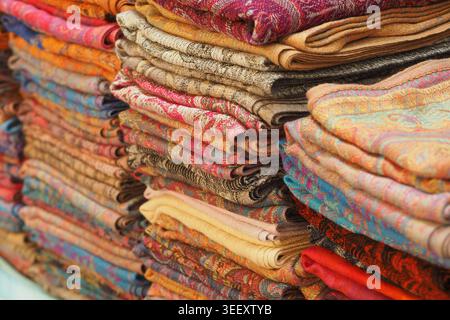 Colorful fabric stacked in a market for sale in India Stock Photo