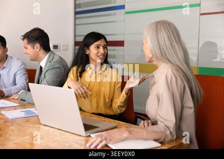 South Asian businesswoman engaging in conversation with female colleague Stock Photo