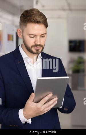 Serious businessman working on tablet in workspace Stock Photo
