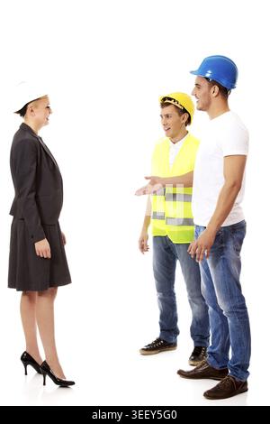 Female engineer talking with two builders Stock Photo