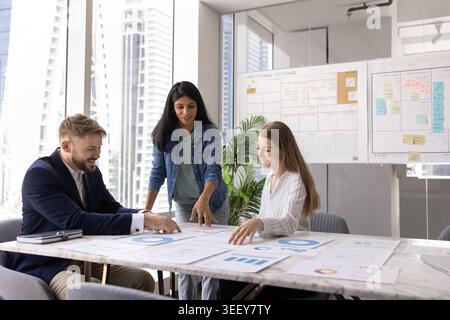 Group of financial analysts analyzing charts and diagrams Stock Photo