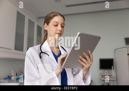 Nurse checking patient data on digital tablet in clinic Stock Photo
