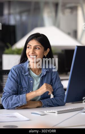 Indian businesslady sitting at desk in modern workplace Stock Photo