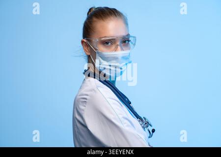 Medical professional wearing protective face mask, safety glasses and stethoscope for healthcare and virus protection Stock Photo