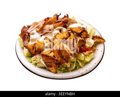 Polish Caesar salad with chicken, bacon and vegetables topped with dressing isolated. High-calorie meat salad with fresh vegetables, Eastern Europe fo Stock Photo